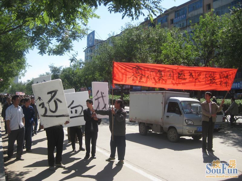 热闹的房展会-场内开放商发传单买房-场外民工举横幅讨债