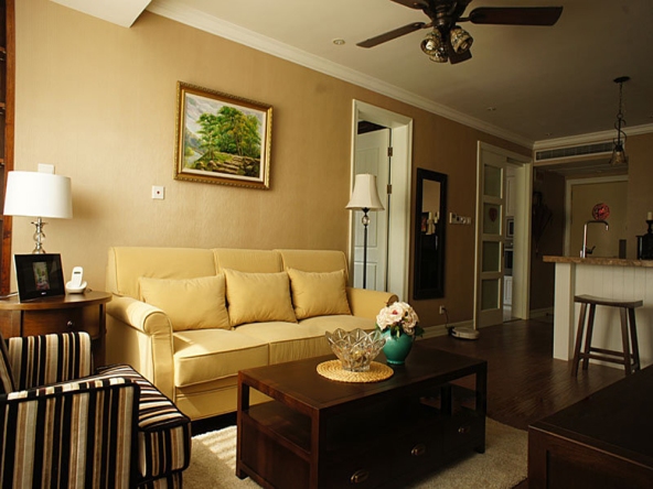 米黄色的沙发和壁纸搭配起来很温馨,实木的家具又显得有些严肃.