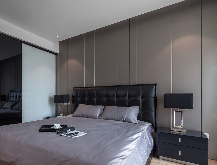 卧室的装饰完全与客厅风格统一,浅灰色的硬包装饰背景.